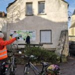 Adhérent et vélos pointant un panneau décrivant un circuit de randonnée
