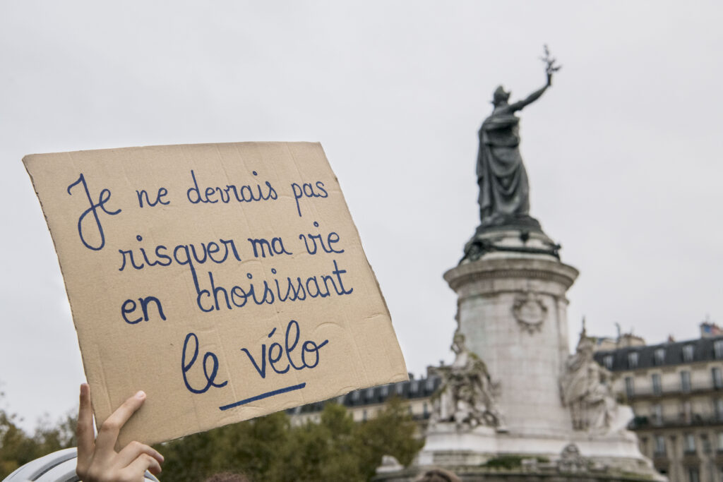 Photographie de Jean Michel Sicot lors d'une manifestation où il est inscrit " Je ne devrais pas risquer ma vie en choisissant le vélo "