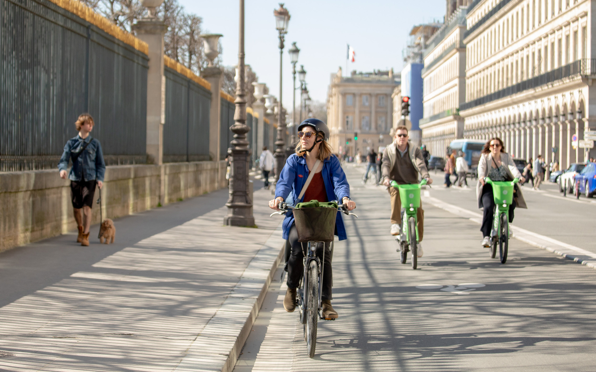 Photographie qui illustre les 4 voies ( trottoir, piste cyclable, voie pour les voitures et voies pour les bus ) sur la Rue de Rivoli à Paris.