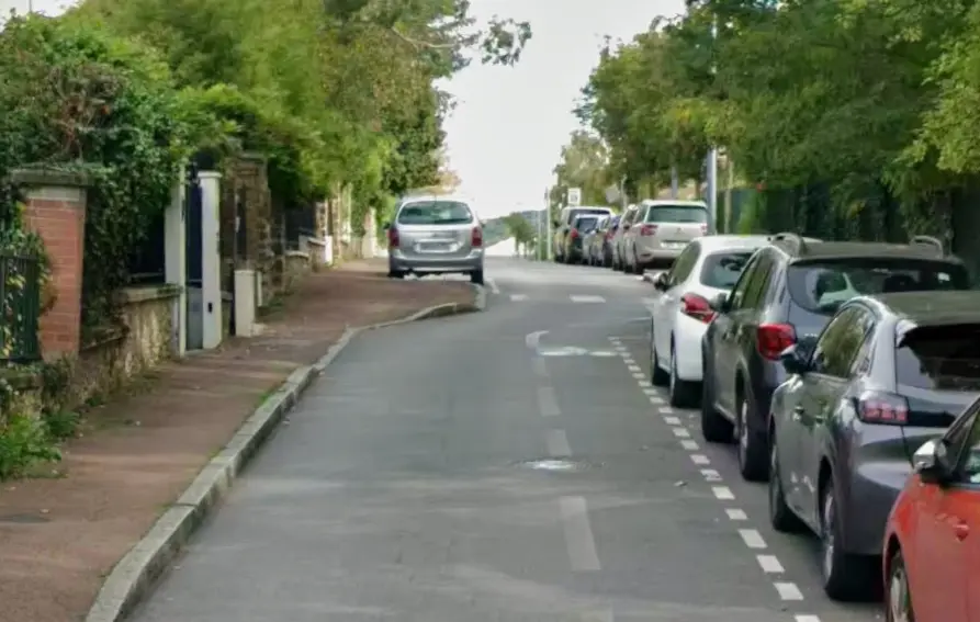 Bande cyclable étroite au bord d'une file de stationnement